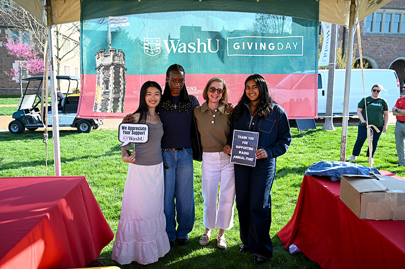 four students in front of Giving Day sign