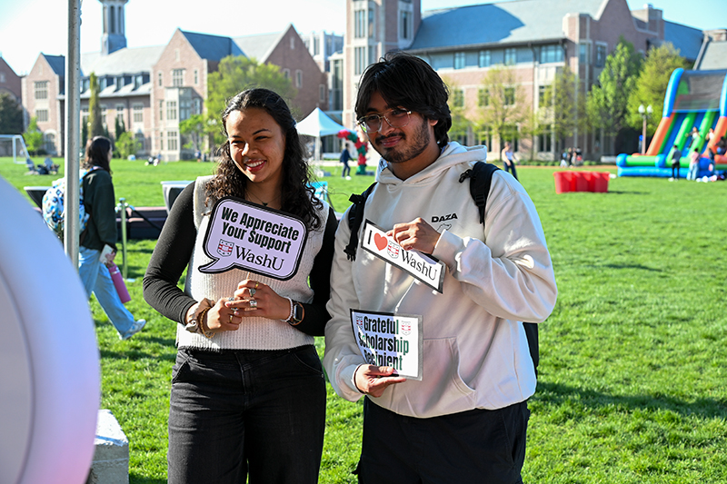 two students holding thank you signs